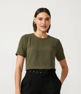 Blusa Cortelle color verde militar, con cuello redondo y mangas cortas con pespuntes. Presenta cierre trasero en forma de gota con botón y pequeñas aberturas laterales.