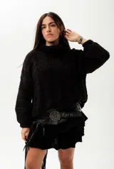 Buzo negro tejido a mano en lana Merino 100% natural, de corte oversize y cuello alto.