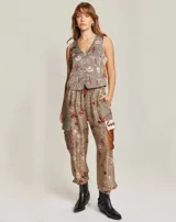 Chaleco con estampado de motivos del lejano oeste en tonos beige, marrón y rojo. Escote en V profundo y cierre frontal con botones.