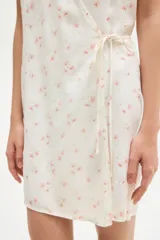 Vestido corto de crepé de viscosa con estampado floral, escote en V y manga japonesa. Tiene frente cruzado con tiras para atar, cuerpo entallado y falda con leve vuelo.