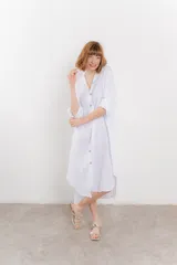 Vestido camisero midi color verde militar, confeccionado en lino 100%. Tiene cuello camisero, botones frontales y mangas 3/4 con botón para ajustar. Presenta silueta oversize y aberturas laterales.