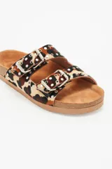 Sandalias de cuero vacuno con estampado animal print, forro de cuero vacuno y suela de caucho. Presentan dos tiras con hebillas ajustables y apliques de tachas metálicas.