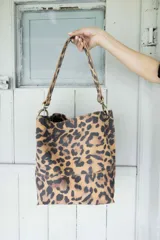 Cartera tipo tote bag con estampado animal print de leopardo, con doble asa corta y herrajes dorados.