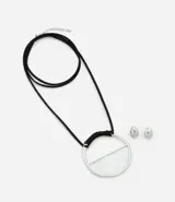 Conjunto de collar con cordón negro, colgante geométrico plateado y caravanas botón plateadas.