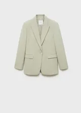 Blazer color verde claro, con cuello de pico con solapa y solapas con muesca. Tiene forro interior, manga larga con puños abotonados, dos bolsillos de solapa en la parte delantera y cierre delantero con botones.
