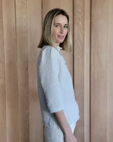 Camisa color beige claro con cuello con volados y mangas 3/4 abullonadas.