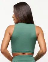 Top deportivo blanco de corte cropped, con cuello alto y logo estampado en el frente.