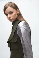 Chaqueta amarilla de paño con cuello mao, cierre frontal con botones, cuatro bolsillos frontales y mangas largas con puños metalizados. Presenta un volado en el contorno del cuello y el frente.