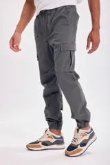 Pantalón cargo jogger gris oscuro con bolsillos laterales y tobillos ajustados.