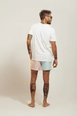 Short de baño para hombre, tiro medio, con estampado tropical en tonos rosados, verdes y blancos. Posee cintura elástica con cordón de ajuste trenzado y bolsillos laterales.