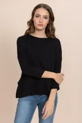 Remera negra de tejido rib con cuello redondo y mangas largas.