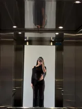 Falda larga de tejido de punto calado color negro, con elástico en la cintura y hebilla metálica plateada.