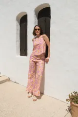 Top sin mangas con estampado floral en tonos rosa y naranja, con cuello redondo y espalda descubierta atada con tres lazos.