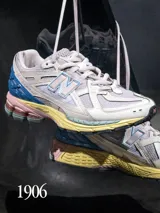 Championes New Balance modelo M1906NC, color crema con detalles en celeste, azul, amarillo y rosa.