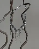 Collar plateado de eslabones gruesos y cadenas finas con dijes de estrellas de diferentes tamaños y colgantes de strass.