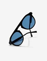 Gafas de sol unisex Hawkers, con montura negra y lentes azules.