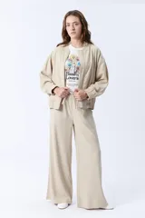 Pantalón beige de corte palazzo con cintura elastizada y cordón ajustable.