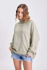 Sudadera de manga larga color beige claro con cuello redondo y mangas raglán.