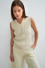 Chaleco tejido marrón con escote en v y sisas amplias. Diseño con diferentes puntos combinados en el frente.