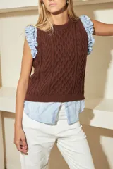 Chaleco marrón de punto con diseño trenzado, cuello redondo y sisas con volantes celestes.