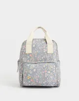 Mochila negra de cuerina con doble asa corta de mano con textura, correas regulables, cierre superior, bolsillo frontal con cierre, bolsillos laterales y tag en relieve.