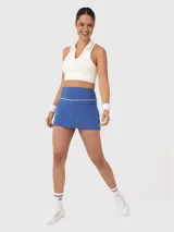 Falda deportiva negra con short incorporado y cintura alta con detalle de línea blanca.