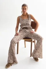 Pantalón de lino con estampado floral en tonos marrones y blancos, corte palazzo y cintura alta.