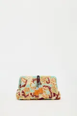 Bolso de mano tipo sobre con cuerpo cubierto de cuentas y abalorios en tonos celeste, beige, naranja y marrón. Tiene asa de cadena extraíble, bolsillo interior con cremallera y cierre con clip imantado y lazo.