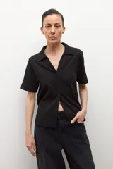 Camisa de manga corta color ciruela, con cuello camisero y cierre frontal de botones.