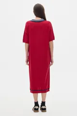Vestido midi tejido color rojo con cuello polo a rayas azul marino y blanco, manga corta con detalle de rayas azul marino y aberturas laterales.