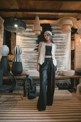 Chaleco negro de vestir, con escote en V y cierre frontal de botones dorados.