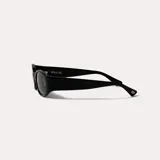 Lentes de sol Stussy modelo Luna, con montura ovalada de acetato color negro y lentes grises.