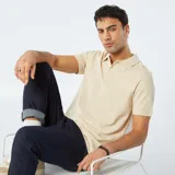 Chomba de piqué de algodón color beige con cuello clásico y tapeta de dos botones.