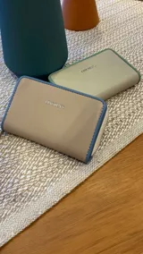 Billetera mediana negra con cierre alrededor y detalles en verde flúor. Interior con visor, tarjeteros y bolsillos. Compartimento posterior con cierre metálico, incluye bolsillos y monedero con cierre.