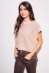 Chaleco de punto color beige con lurex, de corte recto y mangas cortas. Tejido calado con pequeños agujeros.