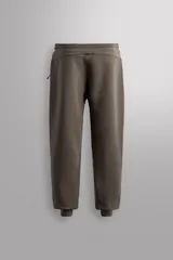 Pantalón jogger color marrón oscuro, corte regular fit, confeccionado en tejido técnico compacto de algodón con elasticidad. Cuenta con cintura elástica ajustable con cordón, bolsillos frontales y bolsillo lateral con cierre de cremallera.