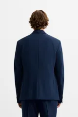 Blazer slim fit azul marino confeccionado en tejido con viscosa. Tiene cuello con solapas de muesca, manga larga con puño con botones, bolsillo de vivo en el pecho, bolsillos de solapa en la cadera, bolsillo interior y aberturas en la espalda.