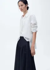 Falda midi de denim color azul oscuro, con diseño evasé y tiro alto.