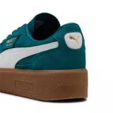 Championes Puma Palermo Elevata, color negro con franja blanca y suela marrón.