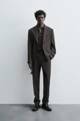Pantalón de vestir negro de lana, corte recto, con bolsillos laterales y traseros de ojal con botón.