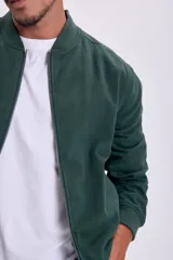 Campera bomber verde con cierre frontal y cuello, puños y cintura acanalados.