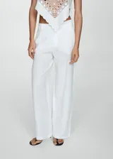 Pantalón amplio de lino color blanco, con corte recto y detalle de pliegues.
