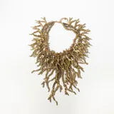 Collar dorado con múltiples cadenas de eslabones y colgantes con forma de ramas.
