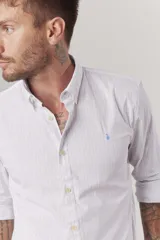 Camisa de hombre color crema, de corte clásico, con cuello abotonado y mangas largas.