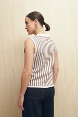 Chaleco tejido de punto sin mangas con rayas verticales azul marino y blancas, cuello polo blanco y corte ajustado.