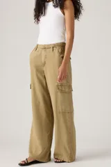 Pantalón cargo color arena, de corte amplio, con bolsillos laterales y cinturón con hebilla metálica.