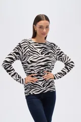 Sweater de tejido de punto, color crema, con estampado floral en tonos rosados y marrones. Presenta cuello redondo y mangas largas.