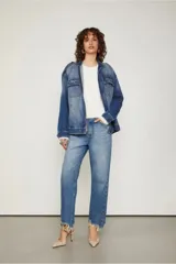 Chaqueta de jean azul con corte oversized, bolsillos con solapa en el frente, cierre metálico y detalles de desgastado suave.