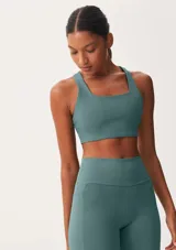 Top deportivo color verde azulado, de corte cuadrado y tirantes anchos.