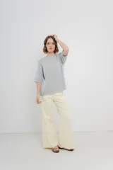 Pantalón de tiro alto, corte palazzo amplio y fluido, color celeste claro. Presenta bolsillos delanteros y traseros tipo jean, con logo metálico Peach en la parte posterior.